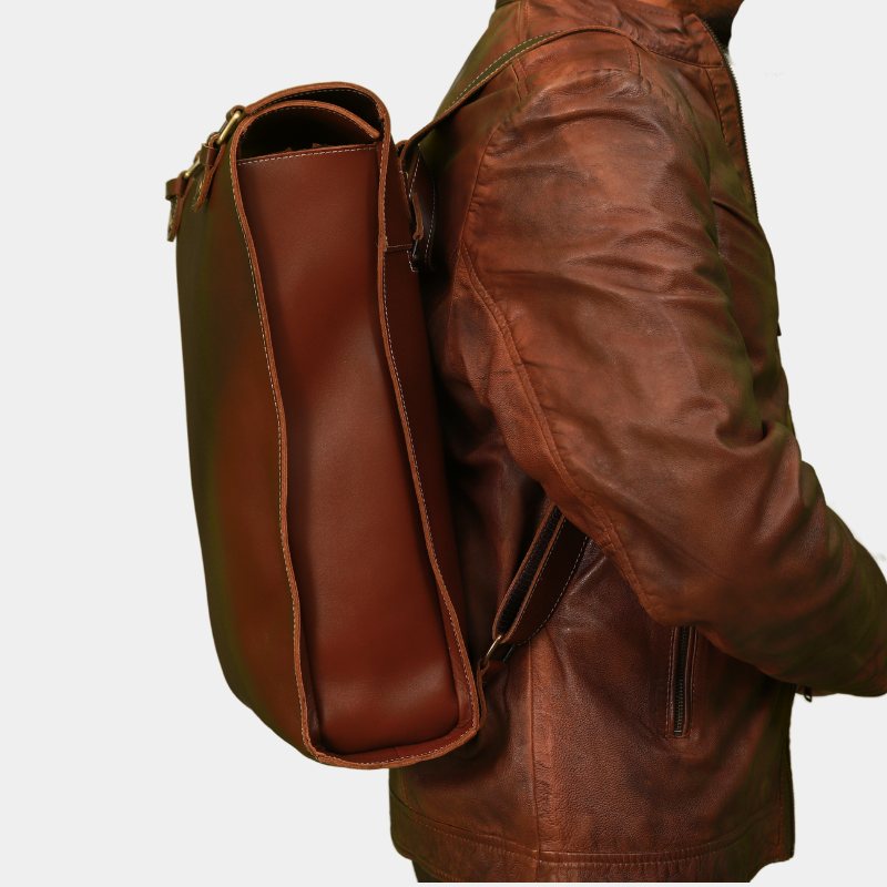 Model in brown jacket posing side view of premium brown leather backpack