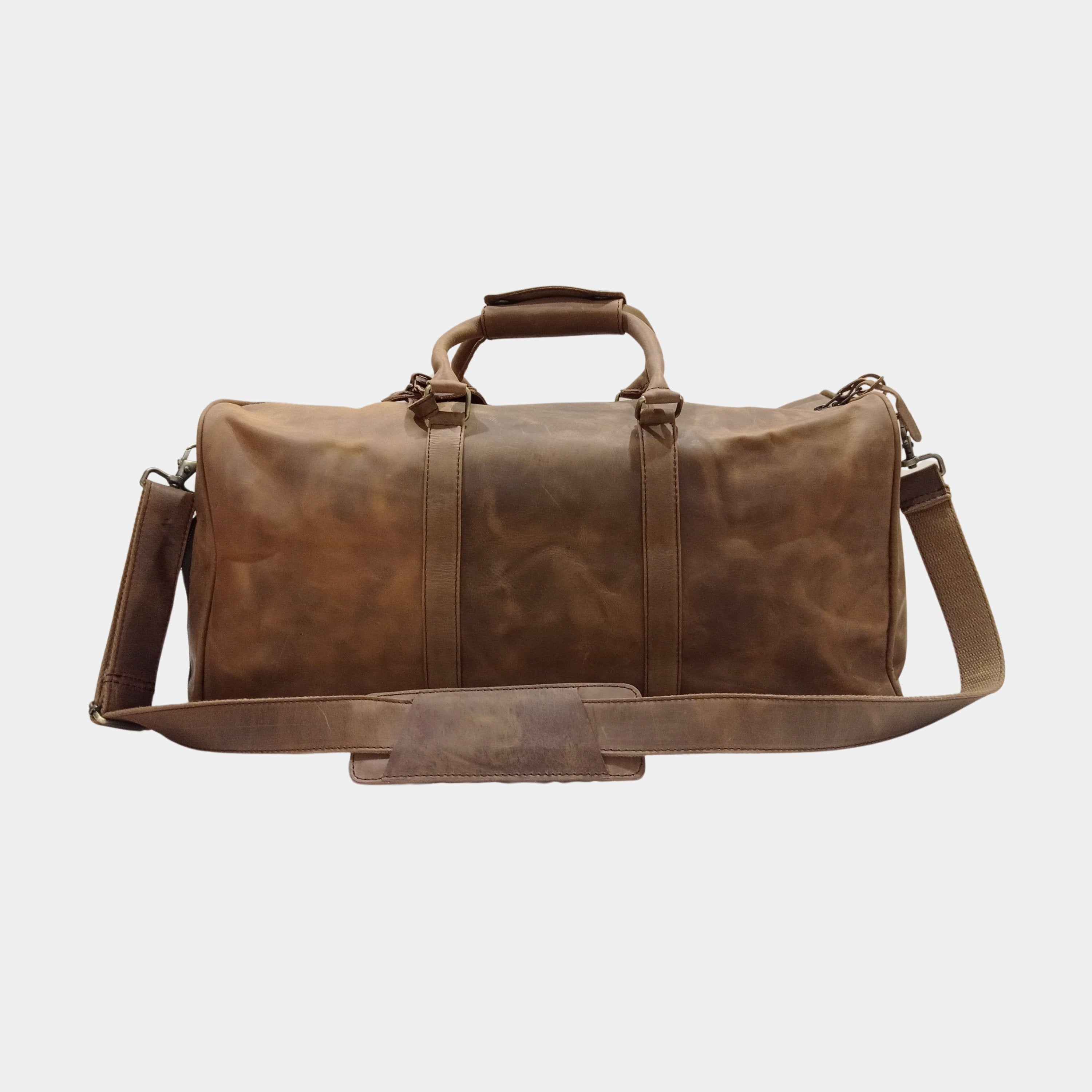 Backside view of Eyre brown bag with adjustable leather strap attached