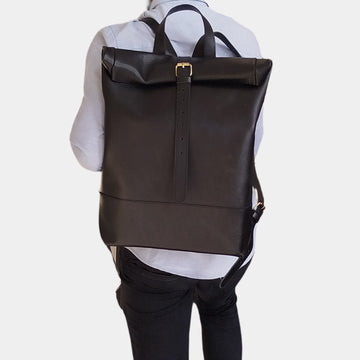 A guy in white shirt holding Stylish leather black flinders backpack for men and women