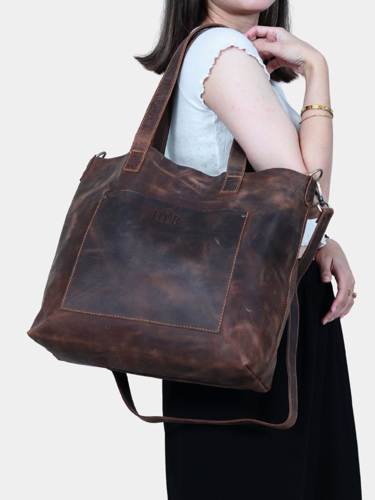 Teenage girl in white shirt elegantly carrying large brown work tote with durable removable straps 