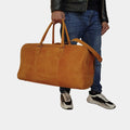 Model in blue jeans elegantly holding Outback Explorer Duffle Bag in his hands