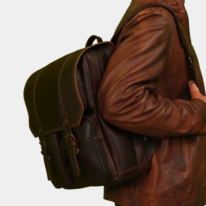Model posing with voyager classic Compact leather backpack on his shoulder with secure zippers, ideal for travel