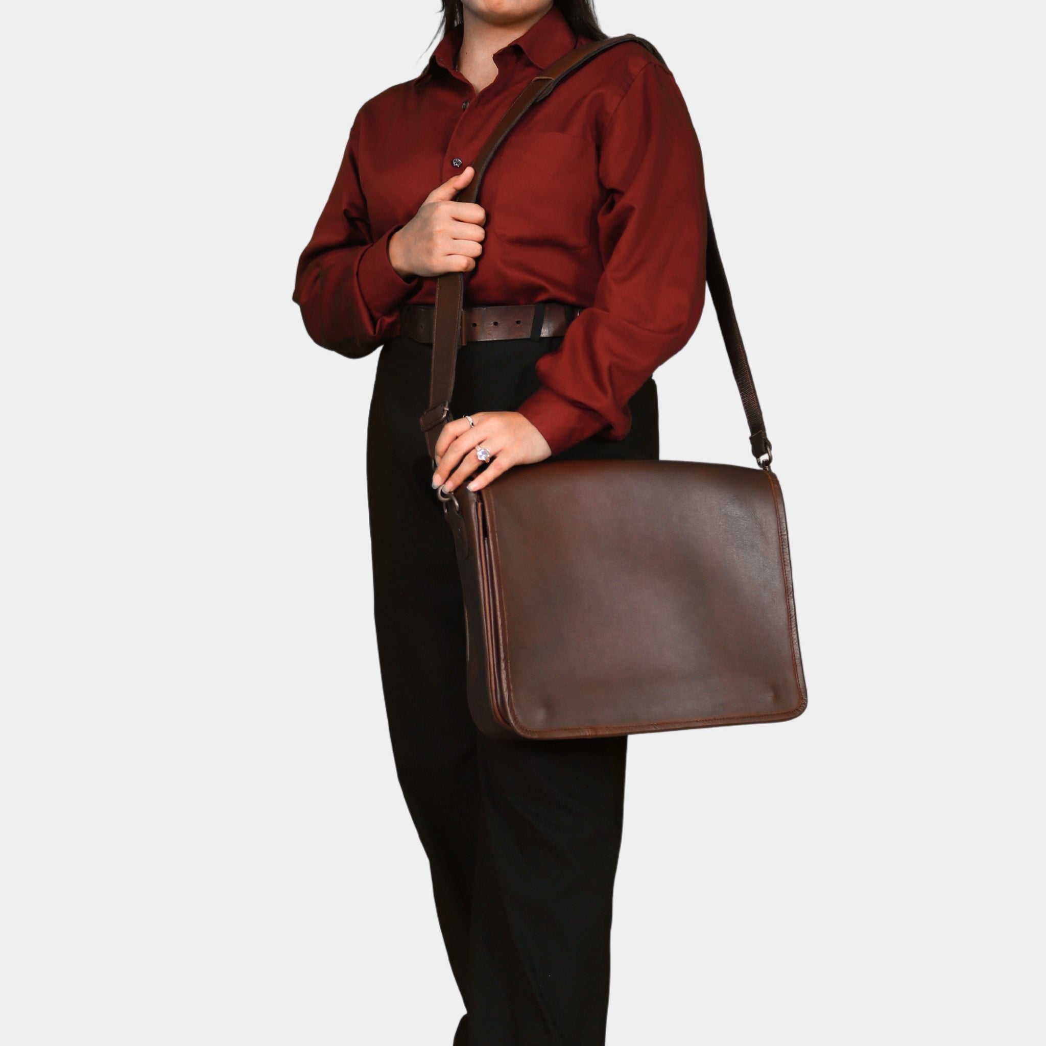 A model slinging The Brown Executive Leather Messenger Bag at her shoulder in formal dress