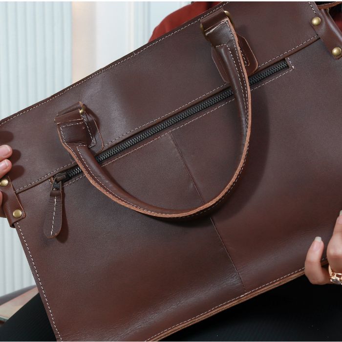 Model holding Dark Brown city chic leather Messenger Bag Australia in her hands showing back zipper pocket