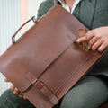 A guy in Green suit showcasing magnetic flap of Brown Business Navigator Leather Messenger bag