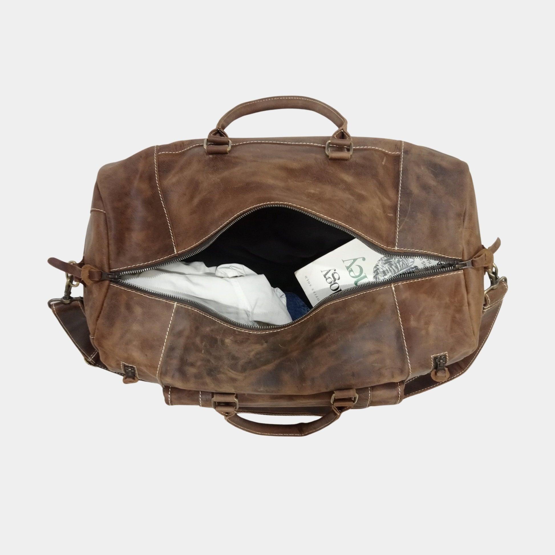 Packed Roma Leather Duffle Bag with clothes nicely arranged and book on top of cloths