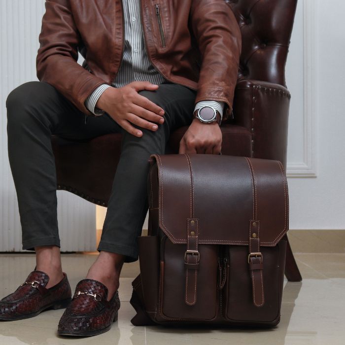 Model holding Voyager classic spacious leather backpack for laptops, books, and everyday essentials