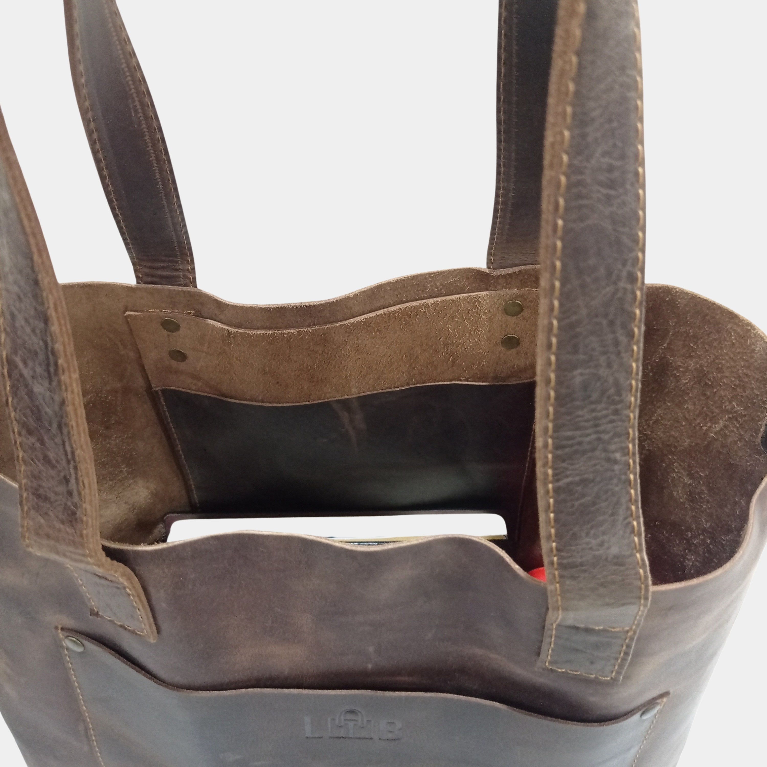 Side slinging pocket inside brown leather tote bag and unlined soft