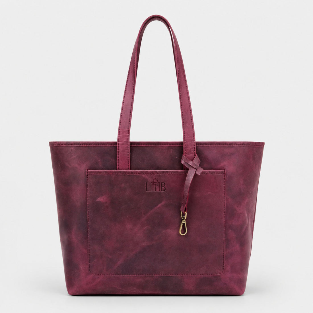 A smiling woman modeling the Emily Leather Tote in Vintage Burgundy by The Leather Bags (TLB) Australia, carrying the full grain crazy horse leather bag over her shoulder inside a cafe setting